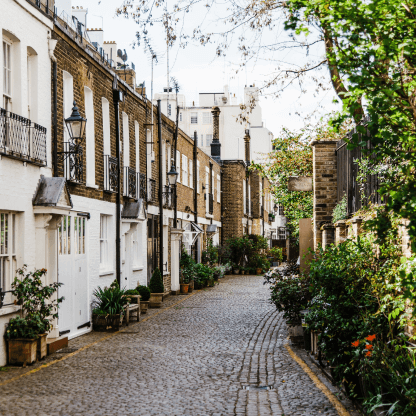A cobblestone street lined with buildings and trees, representing Lendhub's refurbishment loan product.